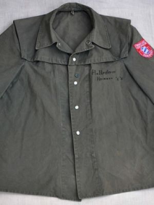 Feuerwehreinsatzjacke, grün, mit Druckknöpfen, Hersteller unbekannt. Herstellungsjahr nach 1950, wahrscheinlich um 1960. (Abgelöst durch den Feuerwehrschutzanzug (2) Anfang/Mitte der 1970er Jahre.)