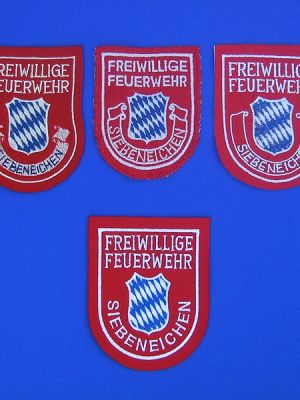 Oben: verschiedene alte Ausführungen des Ärmelabzeichens, die alle noch getragen werden. Unten zum Vergleich die neueste Variante.